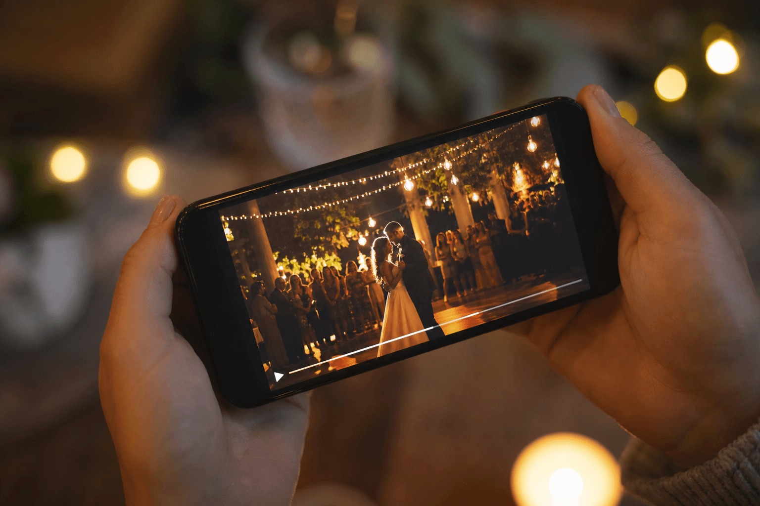 Kurzer Social-Media-Clip einer Hochzeit auf einem Handybildschirm mit romantischer Feierbeleuchtung